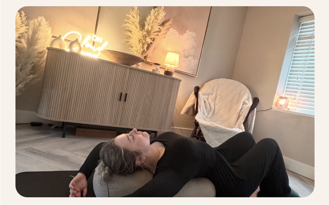Supported reclined rest in a softly lit treatment room with warm neon glow
