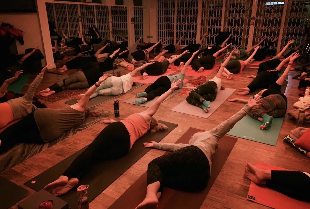 Community yoga class practising together in a village hall