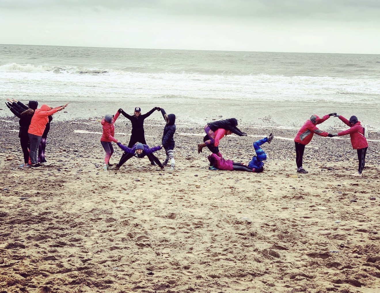 Group making shapes on the beach on a windy Yorkshire coast day